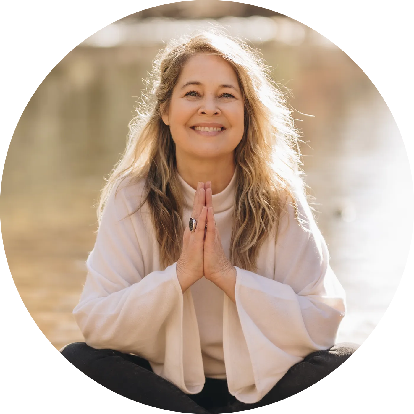 renee-seated-sunlight-circle Renee Trudeau seated near a mountain stream with hands clasped